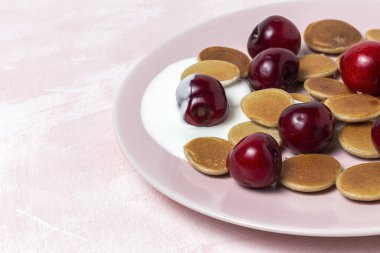 Ev yapımı tahıllar yoğurt, bal ve renkli çilekli mini krep. Sağlıklı kahvaltı kavramı