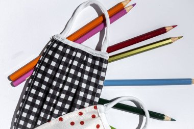 Covid-15. Yeni normallik. Okula Dönüş için malzeme, defterler, yukarıdan renkli kalemler. Düz yatıyordu. Üst görünüm