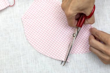 Tanımlanamayan bir kadının elleri kovid19 salgınından korunmak için maske takıyor. Coronavirus Ev Yapımı. makas