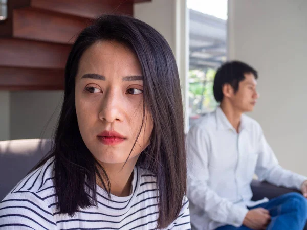 An Asian woman is unhappy and hurt after an argument with her husband due to their distrust. Concepts of family problems and love problems