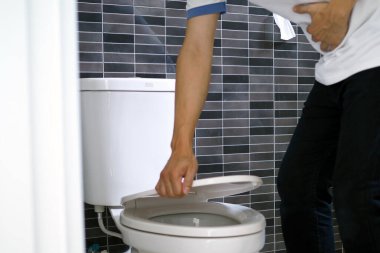 The man caught his stomach and had a painful stomach pain in the bathroom. Want to shit
