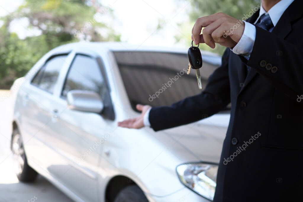 Car salesmen and keys presenting car trading