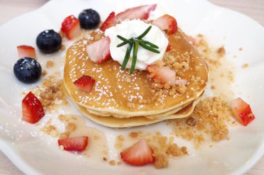 Çilek ve böğürtlen serpilmiş krepler.