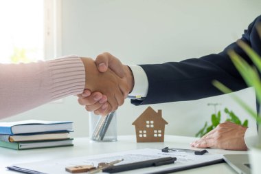 Satış temsilcileri ve müşteriler yeni bir ev ya da daire almak için sözleşme imzaladıktan sonra el sıkışıyorlar. mortgage, ev sahibi konsepti