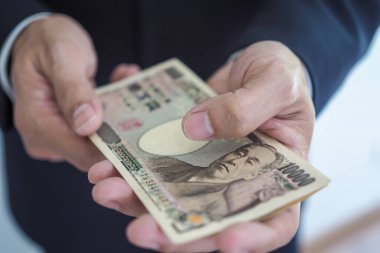 10.000 Japon Yen 'i elinde tutan bir iş adamı. Yatırım, finansal ve ticari açıdan başarılı bir Japon Yen' i..