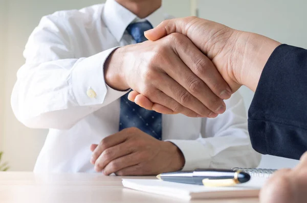 Businessmen shake hands after completing the company registration contract documents. Contract and lawyer meeting concept