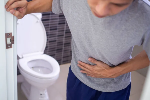 男人因为排尿而有胃痛和雀斑 一个去厕所的男人早上需要排泄 — 图库照片