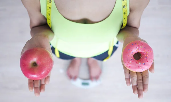 Wanita Mengukur Berat Badan Pada Skala Menimbang Memegang Donat Dan — Stok Foto