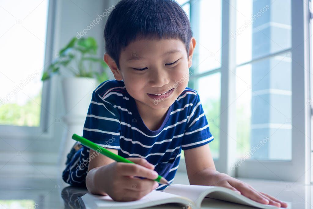 The boys enjoy reading and writing books. Children smile and relax in the living room in the house. Enjoy funny stories in the textbook.