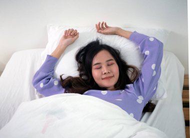 Güzel Asyalı kadın beyaz bir kanepede uyuyor..