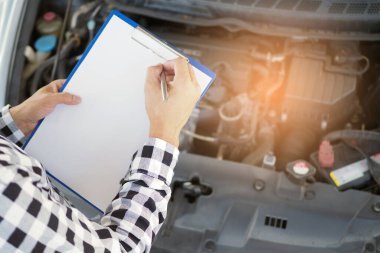 Otoparkta çalışan tamirci motoru kontrol ediyor..