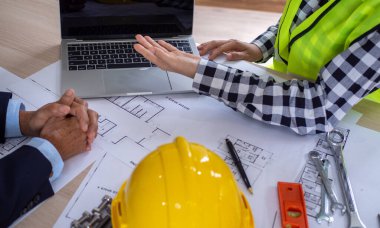 İnşaat projesinin sahibiyle müteahhit arasında bir toplantının fotoğrafı. Yeni bina yapısını yenile