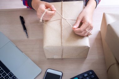 Çevrimiçi satıcılar müşterilere dağıtıma hazırlanmak için ürünleri paketliyorlar. Aile içinde küçük bir iş.