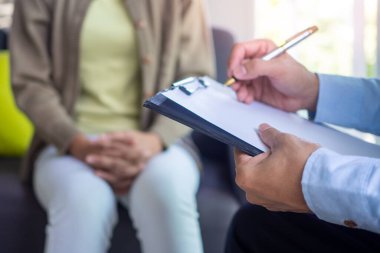 Doktor ya da psikiyatrist kadın hastaların zihinsel hastalıklarını kaydetmek için bir dosya tutuyor. Zihinsel semptomlar ve depresyon tedavisi