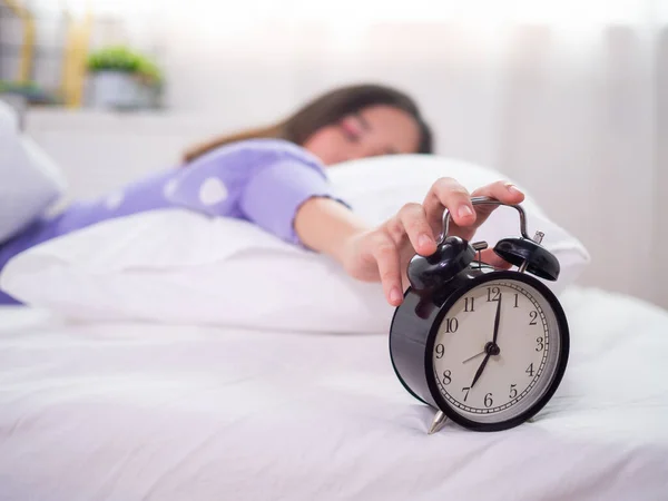 Wanita Mengantuk Tidur Tempat Tidur Menggunakan Tangan Untuk Menekan Jam — Stok Foto