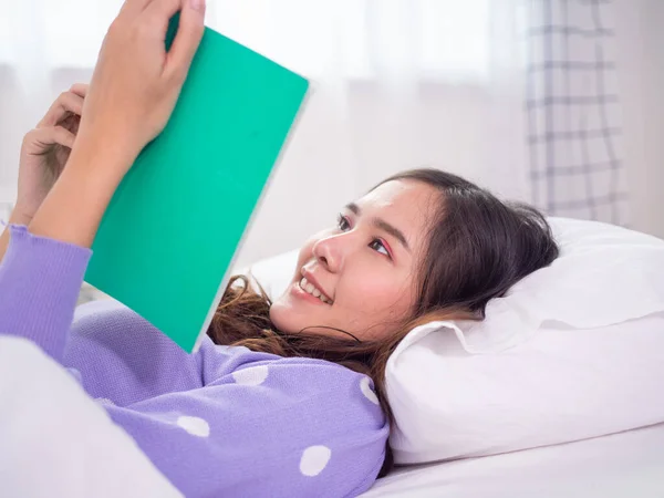 Pandangan Samping Seorang Wanita Muda Membaca Sebuah Buku Sambil Berbaring — Stok Foto
