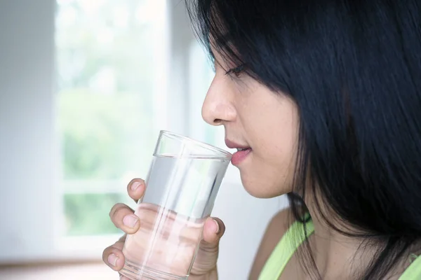 A beautiful Asian woman is happy to drink water. For good health and skin