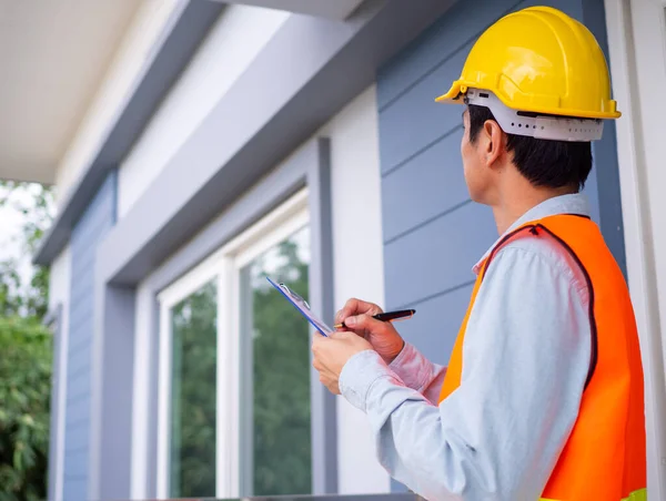 Müfettiş ya da mühendis bina yapısını ve duvar boyasının gerekliliklerini kontrol ediyor. Tadilat bittikten sonra.