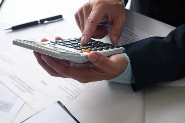 人は計算機を使用し オフィスの費用についての計算とノートを取る 年額納税の準備 — ストック写真
