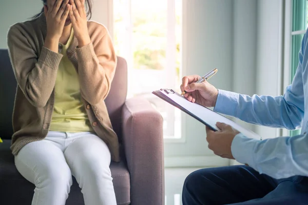 Focused on the hands of a psychiatrist recorded the severe mental illness of girls in the clipboard. Medical and mental health service concepts