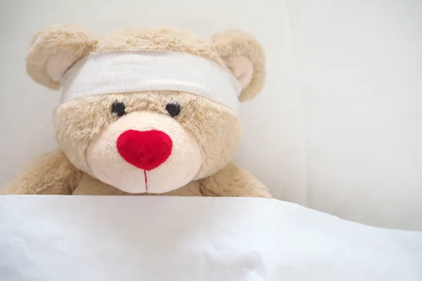 The teddy bear has gauze on the head. Child Injury Concept