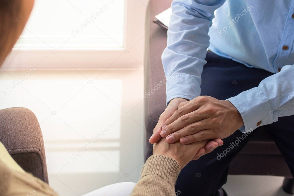 Psychiatrist is touching hands to comfort women with depression or female patients have been sexually abused. Treatment , Listening and consulting concepts. Encouragement and consolation
