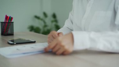 El, QR kodunu taramak için telefonu kullanıyor ve ofiste elektrik faturalarını ödemekten indirim alıyor.