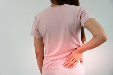 Kadın kendini tutuyor ve dayanılmaz ağrılar çekiyor. Sağlık ve sorunlar, kronik sırt ağrısı, ofis sendromu, skolyoz, bel fıtığı, kas iltihabı.