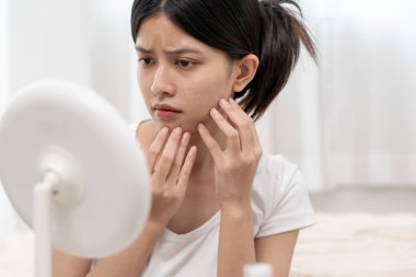 Young woman are worried about faces Dermatology and allergic to steroids in cosmetics. sensitive skin, red face from sunburn, acne, allergic to chemicals, rash on face. skin problems and beauty