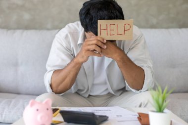 Yüklü faturaları ve faturaları olan stresli ve baş ağrısı çeken Asyalı bir adamın harcamaları ve kredi kartı borçlarını ödeyecek parası yok. kıtlık, mali sorunlar, mortgage, kredi, iflas, iflas, yoksul, boş duvar