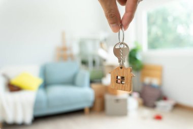 Moving house, relocation. Man hold key house keychain in new apartment. move in new home. Buy or rent real estate. flat tenancy, leasehold property, new landlord, investment, dwelling, loan, mortgage.
