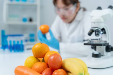 Bilimadamı laboratuvardaki kimyasal gıda kalıntılarını kontrol ediyor. Denetim uzmanları sebzelerin kalitesini inceler. Laboratuvar, tehlikeli maddeler, yasaklı maddeler, kirlilik, mikroskop, mikrobiyolog