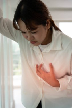 Kalp krizi belirtileri gösteren el ele tutuşmalar, çok çalışan Asyalı kadınların göğüs ağrıları kalp hastalığı, sızıntı, genişleme, kalp büyümesi, göğsüne acı verici bir ifadeyle bastırma.