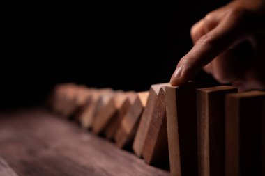 Domino 'yu elleri olan sigorta korur. İş adamı elleri iş krizinde domino taşlarının düşmesini durdurur. işletme risk denetimi ve planlama ve işletmeler sigorta işletmelerini önlemek için stratejiler.