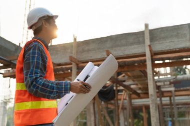 Müfettiş ya da mühendis mavi baskı kullanarak inşaat ve kalite güvencesini denetliyor. Mühendis, mimar ya da irtibat kurucu ev sahibine teslim etmeden önce evi inşa etmek için çalışır.