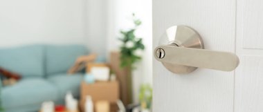 Moving house, relocation. The key was inserted into the door of the new house, inside the room was a cardboard box containing personal belongings and furniture. move in the apartment or condominium