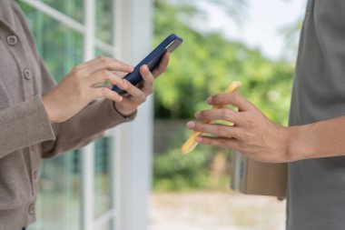 Kadın, ödeme malları için QR kodunu tarıyor. Teslimatçı ekspres teslimat gönderdi. Çevrimiçi dükkan, kağıt konteynır, paket servis, paket, elektronik para, dijital transfer