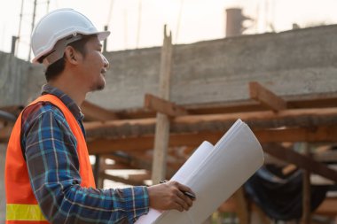 Müfettiş ya da mühendis mavi baskı kullanarak inşaat ve kalite güvencesini denetliyor. Mühendis, mimar ya da irtibat kurucu ev sahibine teslim etmeden önce evi inşa etmek için çalışır.