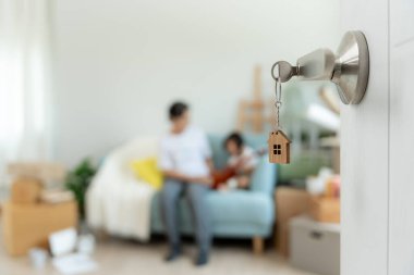 Taşınmak, taşınmak. Kapıyı açtığımda aile gülümsemesi ve yeni bir evde oyun vardı. Odanın içinde kişisel eşyalar ve mobilyalar içeren bir karton kutu vardı. Yeni daireye ya da eve taşınmak.