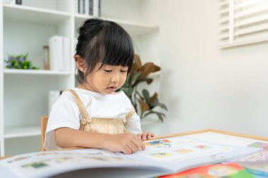 Mutlu Asyalı çocuklar evde kitap okuyarak rahatlar. Kızım ve bir hikaye okuyordum. öğrenme, çocuk bakımı, gülme, eğitim, hikaye anlatma, uygulama, hayal etme, bağımlılık cep telefonunu azaltma