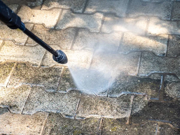 old cleaning the terrace with high pressure cleaner