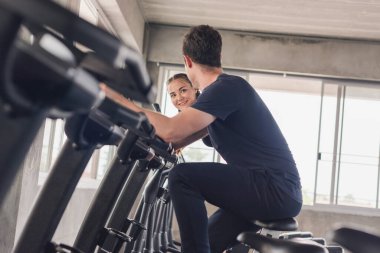 Sporcu, kadın, kız antrenman, spor salonunda bisiklet. Spor kıyafetleri giyiyor..