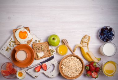 Kahve, portakal suyu, yulaf gevreği, süt, meyve, yumurta ve tost ile kahvaltı. Dengeli beslenme. Sabah tatlı ve lezzetli yemek, gıda arka plan. Tepegöz, yatay