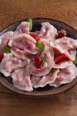 Köfte, çilek ile dolu. Pierogi, varenyky, vareniki, pyrohy - köfte dolgu ile. Yukarıdan görüntülemek, top, ek yükü  