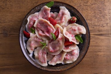 Köfte, çilek ile dolu. Pierogi, varenyky, vareniki, pyrohy - köfte dolgu ile. Yukarıdan görüntülemek, top, ek yükü  