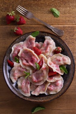 Köfte, çilek ile dolu. Pierogi, varenyky, vareniki, pyrohy - köfte dolgu ile. Yukarıdan görüntülemek, top, ek yükü  