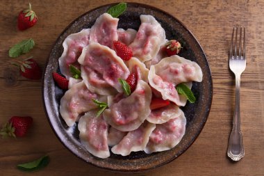 Köfte, çilek ile dolu. Pierogi, varenyky, vareniki, pyrohy - köfte dolgu ile. Yukarıdan görüntülemek, top, ek yükü  