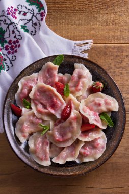 Köfte, çilek ile dolu. Pierogi, varenyky, vareniki, pyrohy - köfte dolgu ile. Yukarıdan görüntülemek, top, ek yükü  