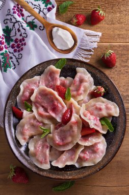 Köfte, çilek ile dolu. Pierogi, varenyky, vareniki, pyrohy - köfte dolgu ile. Yukarıdan görüntülemek, top, ek yükü  