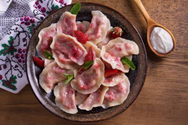 Köfte, çilek ile dolu. Pierogi, varenyky, vareniki, pyrohy - köfte dolgu ile. Yukarıdan görüntülemek, top, ek yükü  